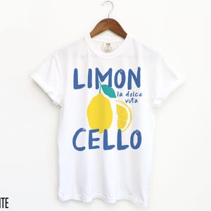 May include: White t-shirt with a blue and yellow graphic of a lemon with the text "Limon Cello" and "la dolce vita" in blue.