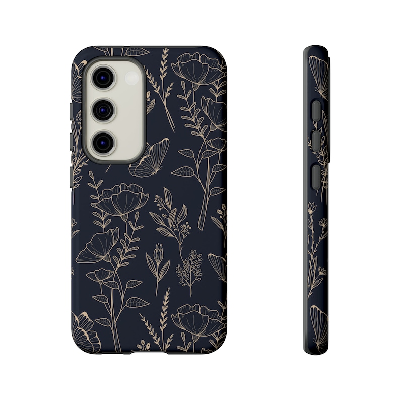 Puede incluir: Una funda de tel&eacute;fono negra con un patr&oacute;n floral en dorado. La funda tiene un recorte para la lente de la c&aacute;mara.