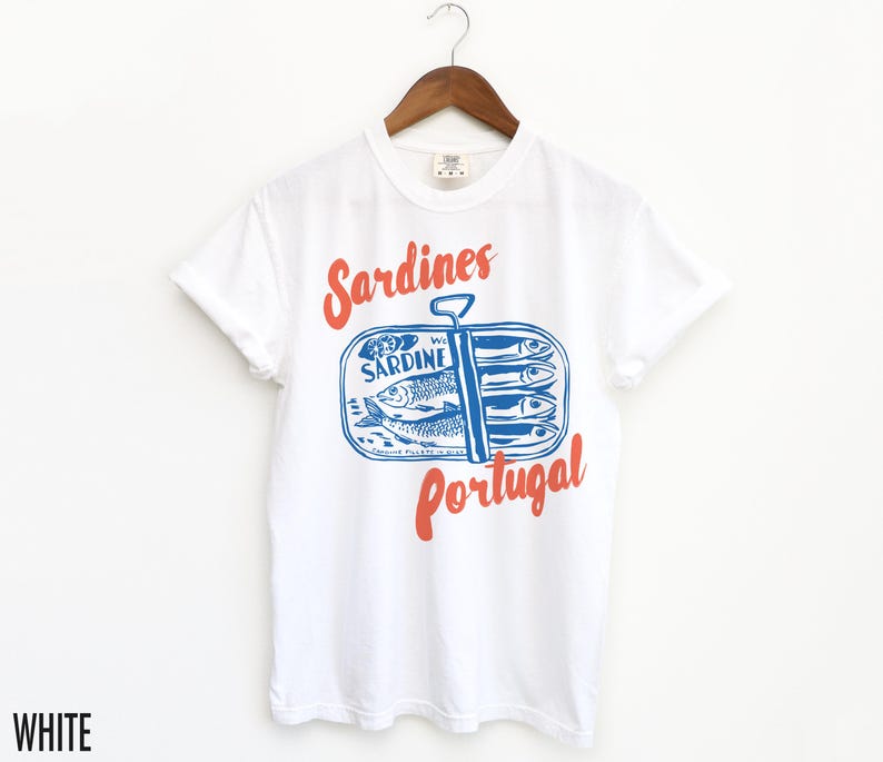 Op de afbeelding: Wit T-shirt met een blauwe en rode afbeelding van een sardineblik met de tekst "Sardines Portugal".