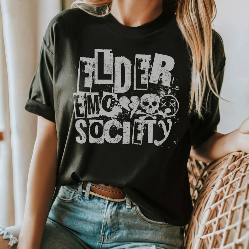 May include: Black t-shirt with a white graphic print that says "Elder Emo Society" with a skull and crossbones design.