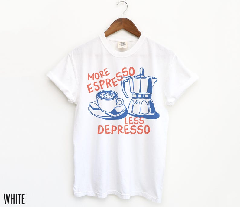 May include: White t-shirt with a blue and red graphic that says "More Espresso Less Depresso". The graphic features a cup of coffee and a coffee pot.