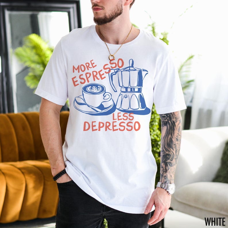 May include: White t-shirt with a blue and red graphic of a coffee pot and a cup of coffee. The text on the shirt reads "More Espresso Less Depresso".