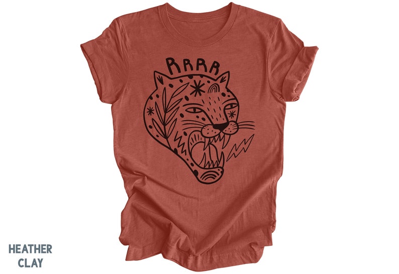May include: A rust-colored t-shirt with a black graphic of a roaring tiger with a floral design and the word "RAAAAR" above it.