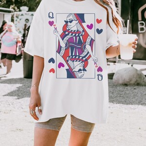 May include: White oversized t-shirt with a graphic print of the Queen of Hearts playing card. The Queen is wearing sunglasses and holding a flower. The card is surrounded by hearts.