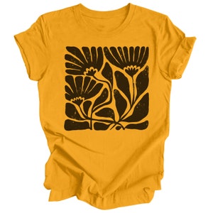 May include: A yellow t-shirt with a black floral print. The print features stylized flowers and leaves.