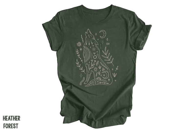 May include: A dark green t-shirt with a white outline of a howling wolf with intricate patterns and symbols. The wolf is surrounded by small floral designs.