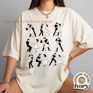 May include: Ivory-colored t-shirt featuring a repeating black and white illustration of couples dancing. The shirt has the text "WWW.ETSY.COM/SHOP/WONKYDESIGNS" printed on the top. The shirt is a Comfort Colors brand.