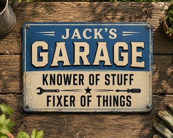 May include: A rectangular metal sign with a blue and cream finish. The text reads JACK'S GARAGE, KNOWER OF STUFF, and FIXER OF THINGS. The design includes a wrench and a screwdriver icon separated by a star, with four corner mounting holes.