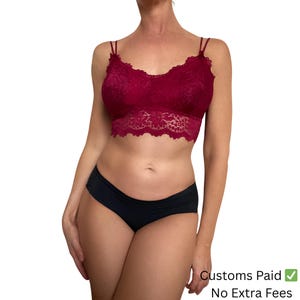 May include: A burgundy lace bralette with thin straps and a scalloped edge is paired with black underwear. The bralette features a floral lace pattern. The image also includes the text "Customs Paid" and "No Extra Fees".