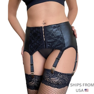 May include: Black garter belt with a faux leather front panel and lace detailing. The belt features adjustable straps and metal clasps. The garment is designed to hold stockings and is shown with black stockings.