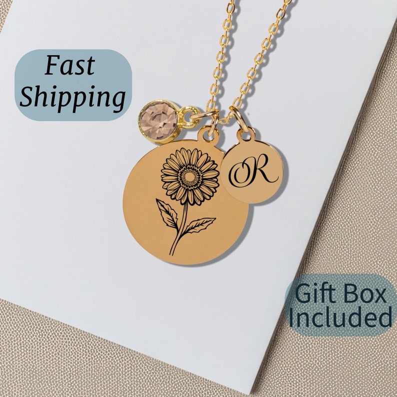 Pu&ograve; includere: Collana d'oro con un ciondolo a forma di girasole, un piccolo ciondolo di cristallo e un ciondolo con la lettera "R" incisa.