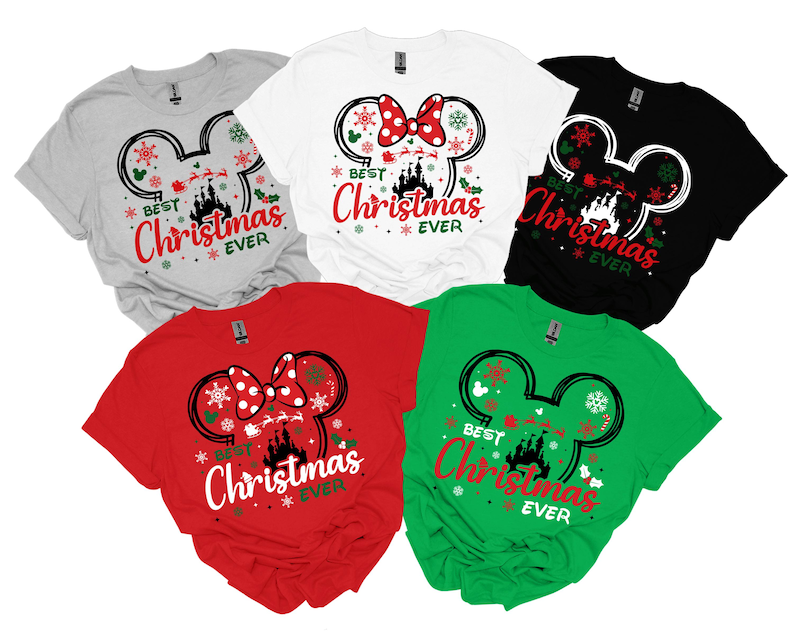 May include: Five short-sleeved t-shirts in gray, white, black, red, and green. Each shirt features a graphic of a Mickey Mouse ear silhouette containing a castle, Santa's sleigh, and snowflakes, with the text "BEST Christmas EVER" printed below.