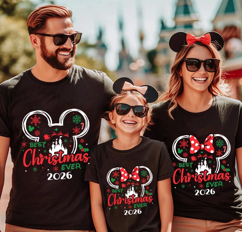 May include: Three black t-shirts featuring a white Mickey Mouse ear silhouette graphic. The design includes a castle, Santa's sleigh, snowflakes, and the red text "BEST CHRISTMAS EVER 2026". The shirts for the two females include a red polka dot bow.