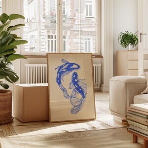 Pode incluir: Uma impress&atilde;o emoldurada de dois peixes koi azuis nadando em um design estilizado. A impress&atilde;o &eacute; em um fundo creme e &eacute; emoldurada em uma moldura de madeira simples.
