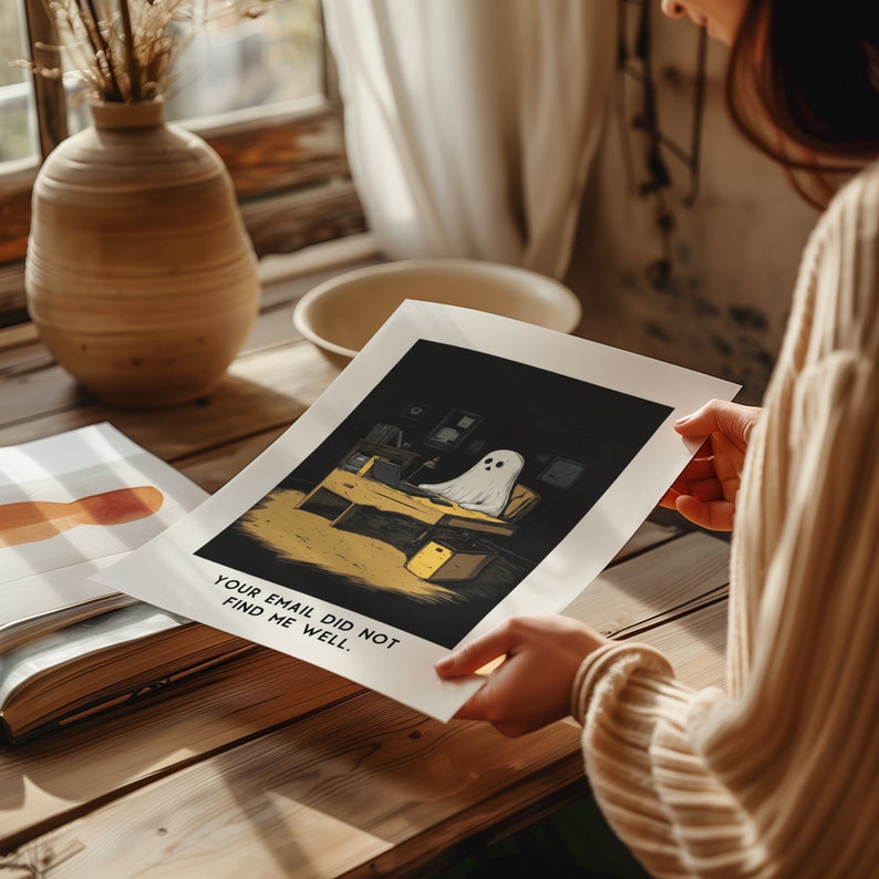 Puede incluir: Una ilustraci&oacute;n en blanco y negro de un fantasma sentado en un escritorio en una habitaci&oacute;n oscura. El fantasma lleva una s&aacute;bana blanca y tiene un brillo amarillo a su alrededor. El texto "YOUR EMAIL DID NOT FIND ME WELL." est&aacute; impreso debajo de la imagen.