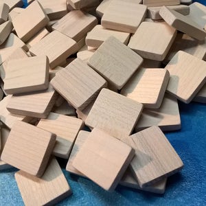 May include: A pile of unfinished, light brown wooden squares on a blue background.