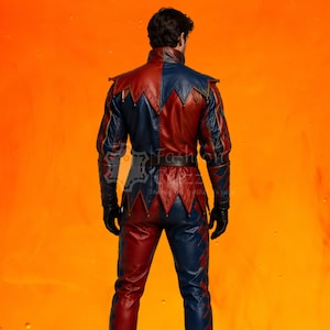 May include: A two-toned red and blue leather jacket and matching pants set featuring a jester-inspired design with pointed hem details on the jacket, long sleeves, and black leather gloves. The garment displays a vertical color-blocked pattern.