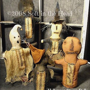 Pode incluir: Cinco bonecas de Halloween de madeira feitas à mão. As bonecas estão vestidas com várias fantasias, incluindo uma bruxa, um fantasma, um espantalho, um gato e um homem de gengibre. Cada boneca tem um corpo de tecido costurado à mão e um rosto pintado. As bonecas estão todas em pé sobre uma superfície de madeira. As bonecas são etiquetadas com seus nomes: "Wicked", "Boo-tiful", "Midnight", "Scaredy Cat" e "Trick or Treat".