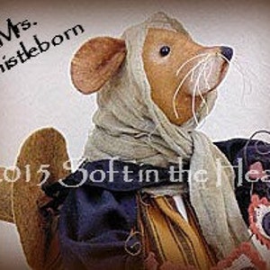 May include: A handmade fabric mouse doll named "Mrs. Thistleborn" wearing a headscarf, dress, and carrying a small bag. The doll has a tan body, brown ears, and long white whiskers. The text "Mrs. Thistleborn" and "©2015 Soft in the Head" are visible.
