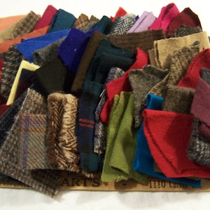 May include: A collection of fabric swatches in various colors and textures. The swatches include shades of red, blue, green, brown, and gray. Some swatches have patterned designs, while others are solid colors. The fabrics appear to be wool or tweed.