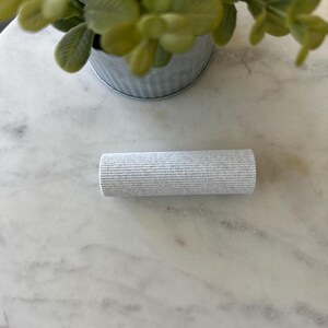 May include: A white ribbed roller for applying paint or other materials.