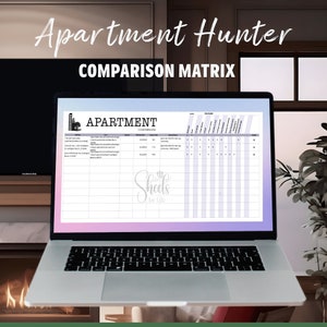 Könnte beinhalten: Ein Laptop-Bildschirm zeigt eine Tabelle mit dem Titel "Apartmentvergleiche". Die Tabelle enthält Spalten für die Adresse des Apartments, den Link, die Kaution, die monatliche Miete, Sonderangebote und Ausstattungsmerkmale. Die Tabelle hat einen helllila und rosa Hintergrund. Der Laptop steht auf einem Tisch vor einem Kamin.