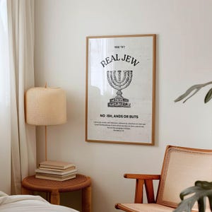K&ouml;nnte beinhalten: Ein Schwarzwei&szlig;druck mit dem Text "REAL JEW" und einer Menora-Illustration. Der Text unter der Menora lautet "NO ISH, ANDS OR BUTS". Der Druck ist in einem hellen Holzrahmen gerahmt und h&auml;ngt an einer wei&szlig;en Wand.