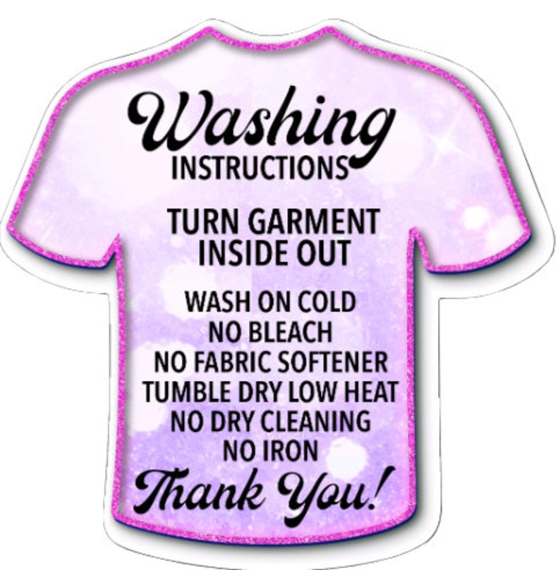 May include: A purple t-shirt shaped tag with pink glitter outlining the edges. The tag has white text that reads "Washing Instructions" and lists instructions for washing a garment: "Turn garment inside out", "Wash on cold", "No bleach", "No fabric softener", "Tumble dry low heat", "No dry cleaning", "No iron", and "Thank You!"