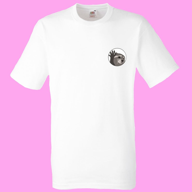 May include: White t-shirt with a circular graphic of a sloth peeking out from behind a circle, waving with its right hand.