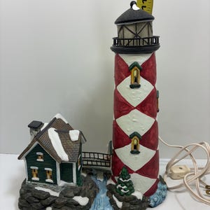 Santa’s work bench lighthouse Village Collector, Christmas, edition, towering cliffs, lighthouse bulb, and cord included.