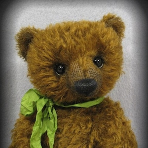 May include: A brown teddy bear with a green ribbon around its neck. The bear has a soft, fuzzy texture and large, dark eyes.
