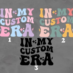 K&ouml;nnte beinhalten: Drei Variationen eines Grafikdesigns mit dem Text "IN MY CUSTOM ERA" im Retro-Stil. Das erste Design ist in Pastellrosa, Blau und Lila. Das zweite Design ist in Pastellrosa, Gr&uuml;n und Gelb. Das dritte Design ist in Schwarz.