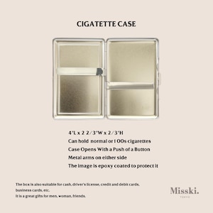 May include: Open metal cigarette case, labeled "CIGATETTE CASE." The case is 4" long, 2 2/3" wide, and 2/3" high. It opens with a button and has metal arms. The image is epoxy coated. Can hold normal or 100s cigarettes.