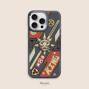 May include: A black phone case with a red, white, and black design. The case features a graphic of a skull with a crown and the words "NOOD KING".