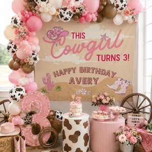 Puede incluir: Una decoraci&oacute;n de fiesta de cumplea&ntilde;os con un tel&oacute;n de fondo que dice This Cowgirl Turns 3! Happy Birthday Avery, adornado con globos rosas, blancos y con estampado de vaca, un n&uacute;mero 3 rosa grande, un pastel, flores y decoraci&oacute;n western.