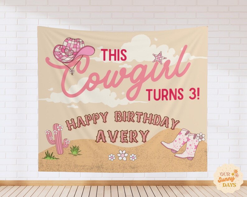 Puede incluir: Un tel&oacute;n de fondo de tela rectangular con un paisaje des&eacute;rtico, un sombrero de vaquero a cuadros rosa, un cactus rosa y botas de vaquero rosas. El texto dice THIS Cowgirl TURNS 3! HAPPY BIRTHDAY AVERY en letras rosas y marrones sobre fondo beige.