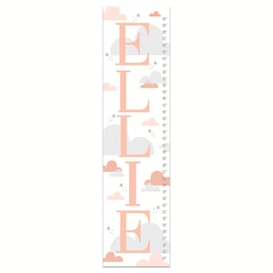 May include: A pink and gray growth chart with the name "ELLIE" spelled out in large pink letters. The chart features clouds and stars and measures from 24 inches to 60 inches.