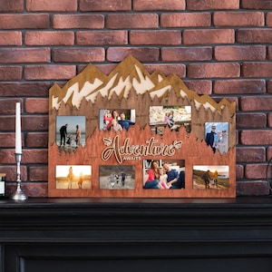 May include: A wooden photo frame shaped like a mountain range with the text "Adventure Awaits" in the center. The frame has eight photo slots, each with a different family photo.