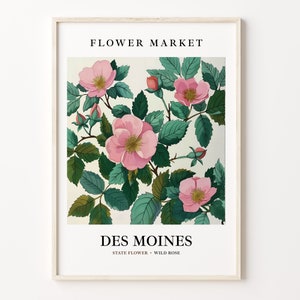 Könnte beinhalten: Eine Vintage-botanische Illustration einer rosa Wildrose, die Staatsblume von Des Moines, Iowa. Die Illustration zeigt eine Gruppe von rosa Rosen mit grünen Blättern vor einem weißen Hintergrund. Der Text "FLOWER MARKET" erscheint oben im Bild, und "DES MOINES" und "STATE FLOWER - WILD ROSE" erscheinen unten.