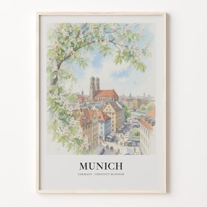 Puede incluir: Una impresión en acuarela enmarcada de un paisaje urbano de Múnich con la catedral Frauenkirche, rodeada de flores blancas de castaño. El texto en la parte inferior dice MUNICH GERMANY CHESTNUT BLOSSOM en una fuente serif negra.