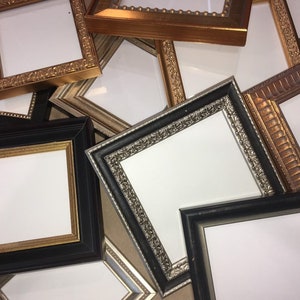 Op de afbeelding: Een verzameling van verschillende fotolijsten in verschillende maten en stijlen. De lijsten zijn gemaakt van hout en hebben een verscheidenheid aan afwerkingen, waaronder goud, zilver en zwart. Sommige lijsten hebben sierlijke ontwerpen, terwijl andere eenvoudiger zijn.