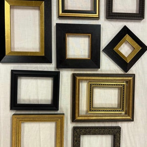 May include: Nine different picture frames in various sizes and styles. The frames are made of wood and have a black and gold finish. Some frames have a simple design, while others have more ornate details.