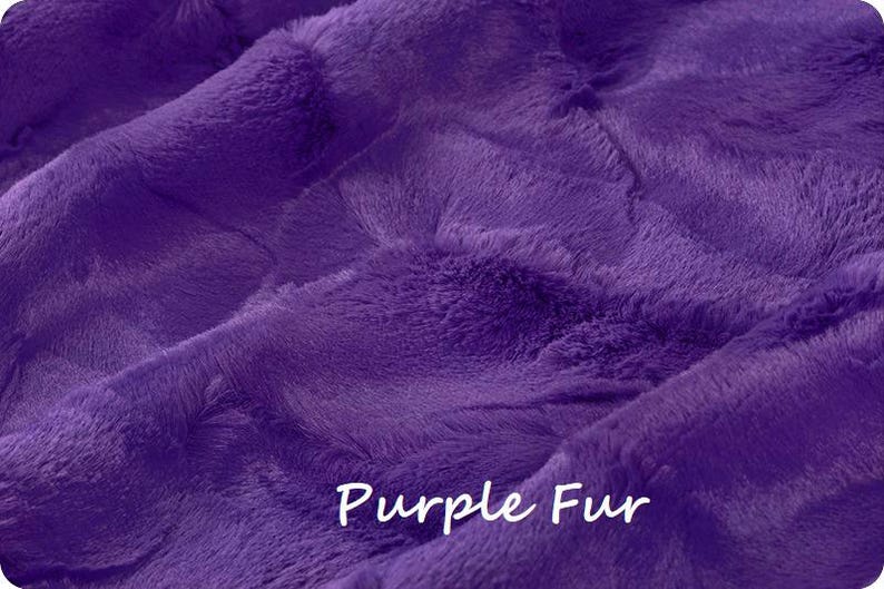 May include: A vibrant purple faux fur fabric with a dense, soft, and plush texture. The surface features deep folds and ripples that create natural shadows and highlights across the material. The text "Purple Fur" is printed in white.