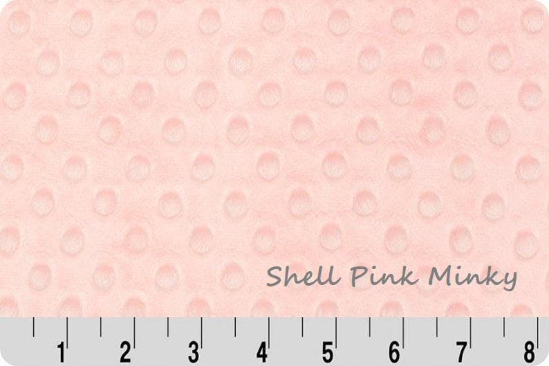 May include: Shell Pink Minky fabric with a raised dot pattern. The fabric is a soft, plush material in a light pink color. A ruler is at the bottom of the image, with measurements in inches.