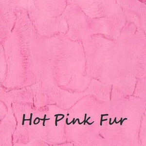 May include: A vibrant hot pink faux fur fabric with a dense, soft, and textured pile. The surface features a swirling, directional pattern characteristic of plush synthetic fur. The text Hot Pink Fur is printed in a dark font across the lower center.