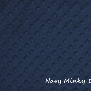 May include: Navy blue minky dot fabric with a soft, textured surface. The fabric has a rounded corner shape and the words "Navy Minky Dot" in white script.