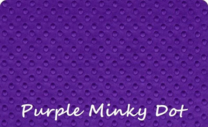 May include: A vibrant purple fabric featuring a raised, embossed dot pattern across the entire surface. The material has a soft, textured appearance with consistent circular indentations. The text Purple Minky Dot is printed in white.