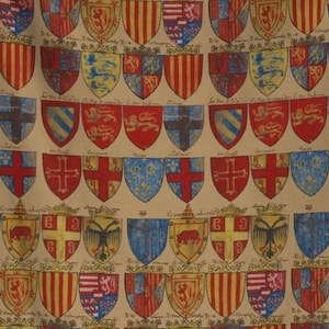 May include: A fabric pattern featuring a repeating grid of historical heraldic shields in shades of red, blue, yellow, and white on a tan background. Each shield displays distinct symbols, including lions, crosses, and stripes, with handwritten text.