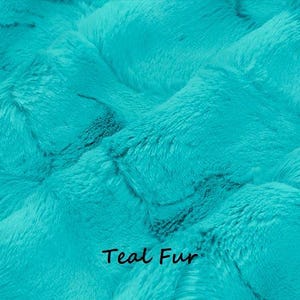 Pu&ograve; includere: Primo piano di tessuto di pelliccia color verde acqua. Il materiale in peluche ha un motivo strutturato e ondulato. Le parole "Teal Fur" sono stampate in nero nella parte inferiore dell'immagine. Questo tessuto &egrave; adatto a vari progetti di artigianato e cucito.