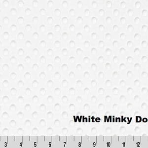May include: White minky dot fabric with a textured surface. The fabric has a pattern of evenly spaced, small, raised dots. The text "White Minky Dot" is displayed on the fabric. A ruler is at the bottom of the image, with measurements in inches.